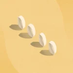 four white pills standing on end with shadows