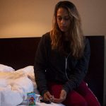 Woman testing her blood sugar in bed at night