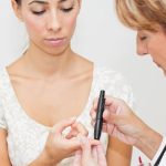 Doctor testing patient for diabetes with a fingerstick test