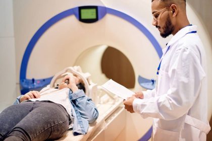 Doctor stands next to patient in an MRI device