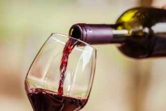 Bottle pouring red wine into a glass