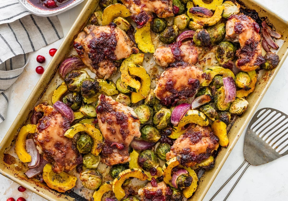 Roasted cranberry balsamic chicken with caramelized veggies on a sheet pan ready to serve.