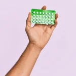 woman holding up contraceptive birth control pills