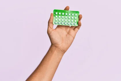 woman holding up contraceptive birth control pills