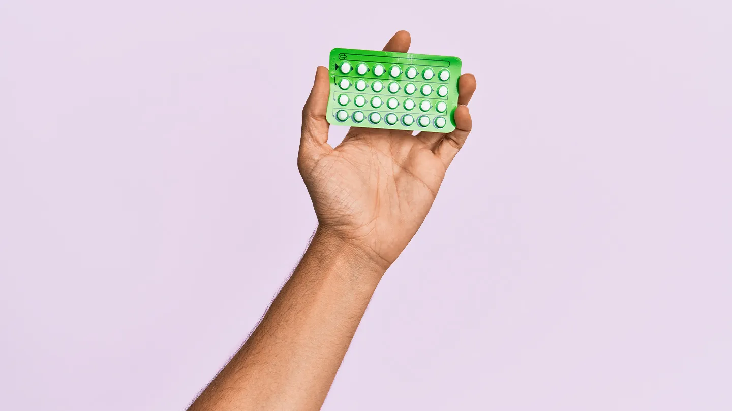 woman holding up contraceptive birth control pills