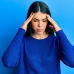 Why do some migraines cause flashing lights or temporary blindness?