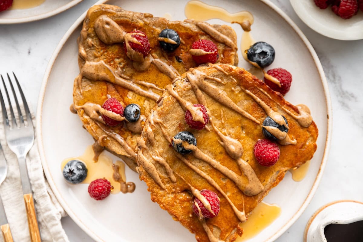 Single-serve protein French toast with blueberries, raspberries, and maple syrup.
