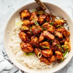 Sweet and savory bourbon chicken served over fluffy rice in a bowl.