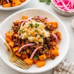 Roasted sweet potatoes topped with ground beef, street corn salsa, pickled red onions, cilantro and hot honey.